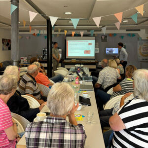 Die Besucherinnen und Besucher des Digital-Café folgen interessiert dem Vortrag zum Thema „Kreditkarten und Onlinezahlungsmethoden“. (Foto: Julia Sterlings/MGH)
