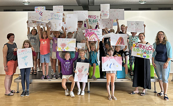 Stolz präsentieren die Kinder ihre Zirkusplakate und zeigen Claudia Pasler von der VHS (rechts) ihre ersten Kunstwerke. (Foto: Maximilian Vogt)
